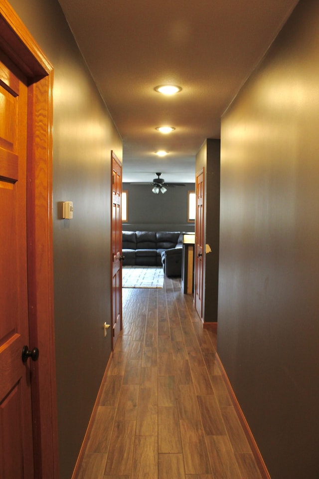 hall with baseboards and dark wood finished floors