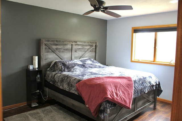 bedroom featuring baseboards, ceiling fan, and wood finished floors