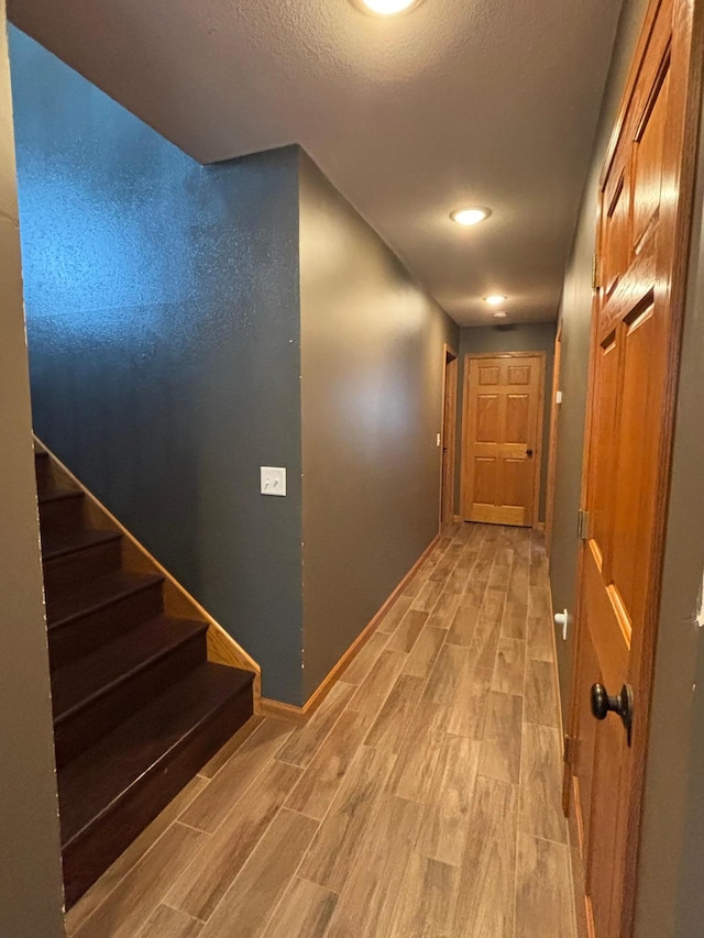 602 Nelson St W, Eagle Bend, MN 56446 - corridor featuring wood tiled floors, baseboards, stairway, and a textured ceiling