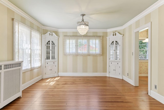 4606 Drexel Ave, Edina, MN 55424 - unfurnished dining area featuring radiator, a chandelier, wood finished floors, wallpapered walls, and healthy amount of natural light