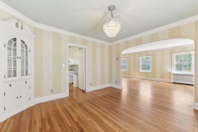 4606 Drexel Ave, Edina, MN 55424 - unfurnished dining area featuring radiator, arched walkways, crown molding, a chandelier, and light wood-style floors