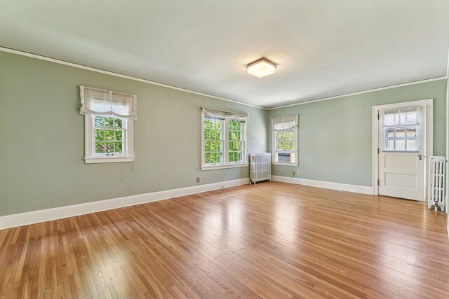4606 Drexel Ave, Edina, MN 55424 - empty room with crown molding, light wood-style flooring, baseboards, and radiator
