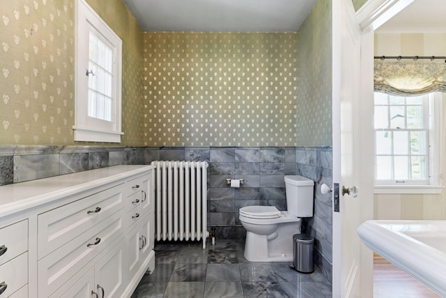 4606 Drexel Ave, Edina, MN 55424 - full bath with radiator, toilet, wallpapered walls, tile walls, and healthy amount of natural light
