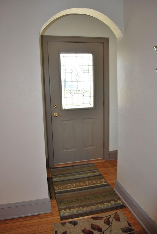 767 Shoreacres Dr, Fairmont, MN 56031 - doorway to outside with arched walkways, wood finished floors, and baseboards