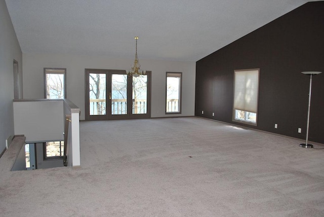 767 Shoreacres Dr, Fairmont, MN 56031 - unfurnished living room featuring a chandelier, carpet flooring, and vaulted ceiling