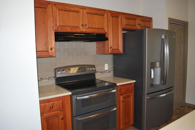 767 Shoreacres Dr, Fairmont, MN 56031 - kitchen with decorative backsplash, stainless steel appliances, under cabinet range hood, brown cabinetry, and light countertops