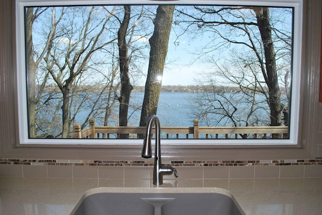 767 Shoreacres Dr, Fairmont, MN 56031 - details with a sink, a water view, backsplash, and light countertops