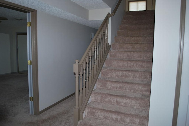 767 Shoreacres Dr, Fairmont, MN 56031 - stairway with baseboards, a textured ceiling, and carpet