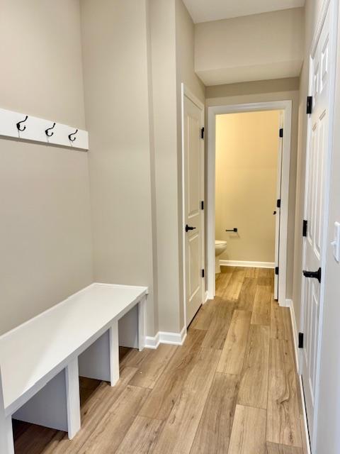 mudroom featuring baseboards and light wood-style floors