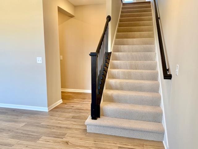 stairs with baseboards and wood finished floors