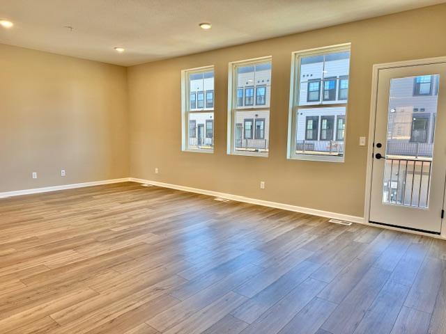 spare room featuring baseboards, recessed lighting, and wood finished floors
