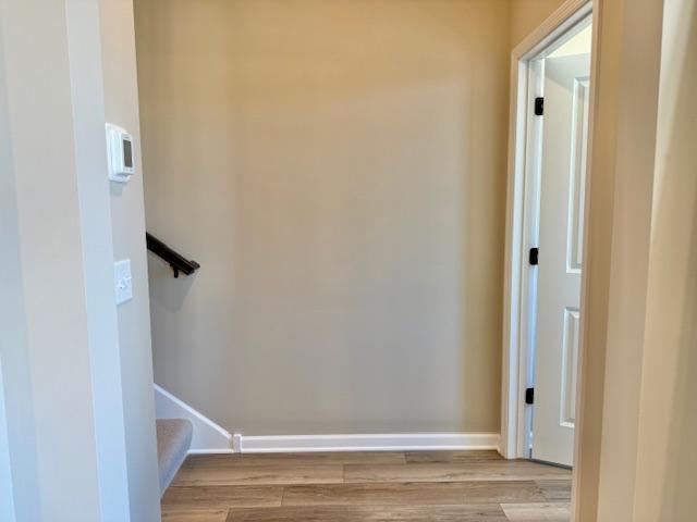 stairway featuring wood finished floors and baseboards