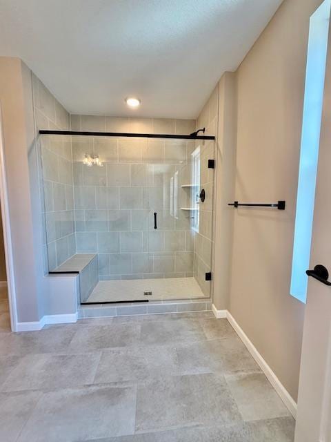 bathroom with a stall shower and baseboards