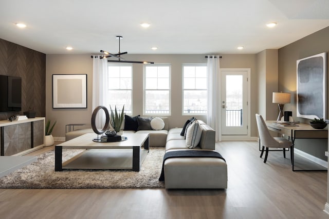 living room featuring recessed lighting, wood finished floors, and baseboards