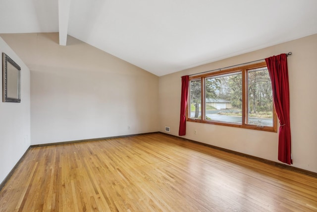 unfurnished room featuring light wood-style floors, lofted ceiling with beams, baseboards, and visible vents