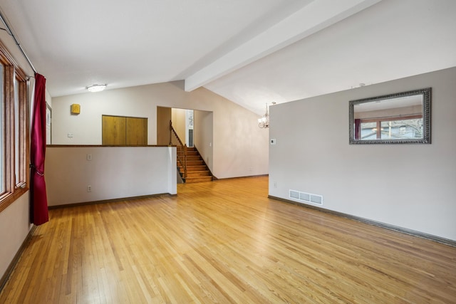 unfurnished room featuring visible vents, stairway, wood-type flooring, an inviting chandelier, and vaulted ceiling with beams