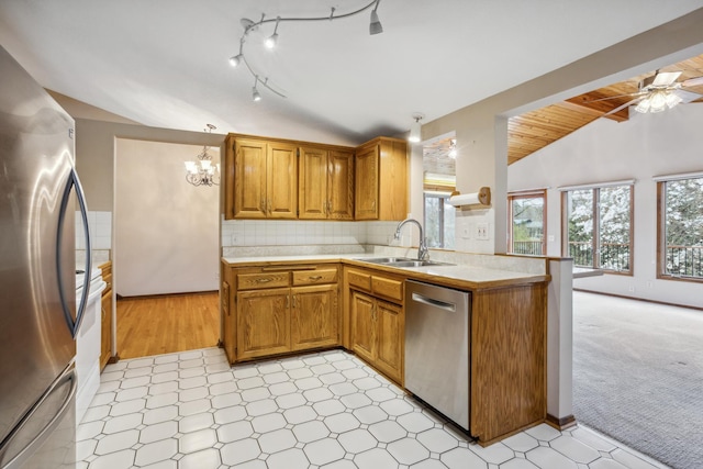 kitchen featuring light countertops, appliances with stainless steel finishes, a sink, and a wealth of natural light