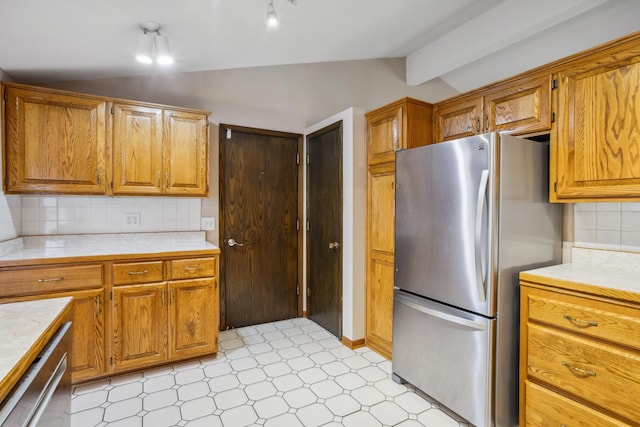 kitchen with decorative backsplash, vaulted ceiling, light countertops, light floors, and stainless steel appliances