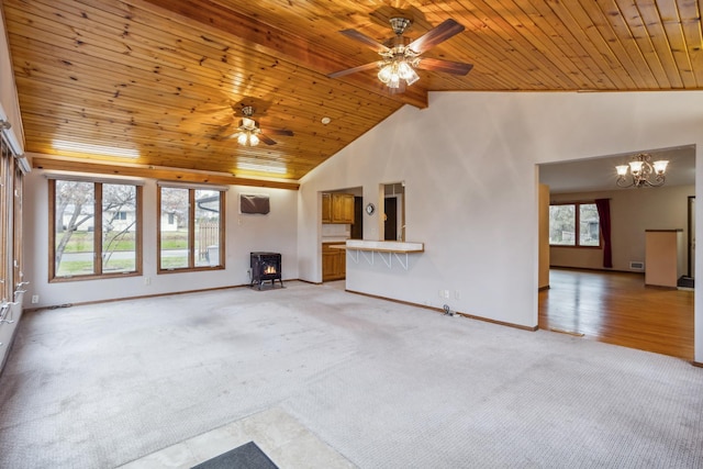 unfurnished living room with baseboards, a wood stove, light carpet, and wooden ceiling