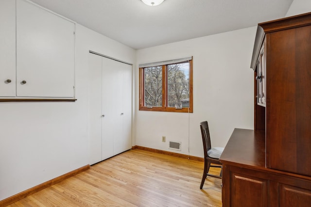 unfurnished office featuring visible vents, light wood finished floors, and baseboards
