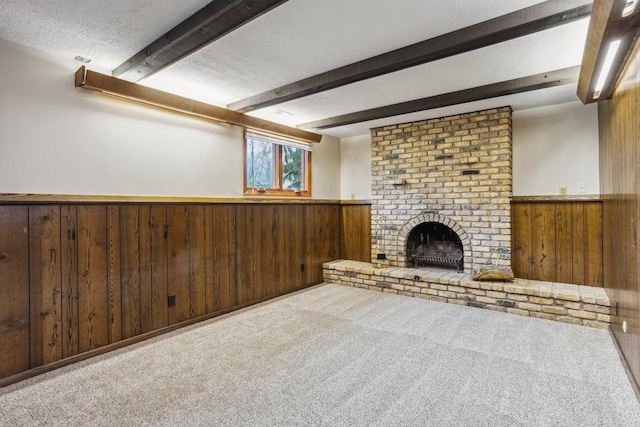 unfurnished living room featuring a wainscoted wall, carpet flooring, wood walls, and beam ceiling