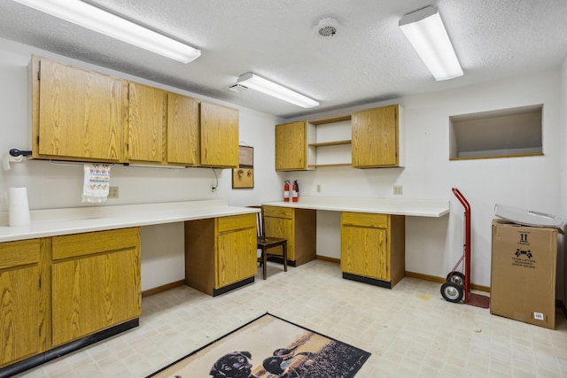 kitchen with light floors, open shelves, a textured ceiling, and brown cabinets
