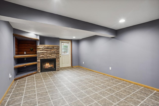 unfurnished living room with baseboards, recessed lighting, and a stone fireplace