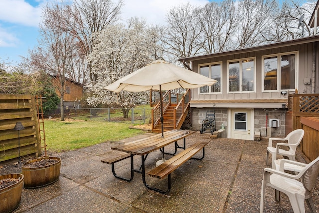 view of patio with outdoor dining area, stairs, a fenced backyard, and a wooden deck