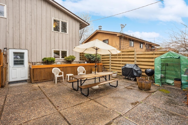 view of patio featuring fence, outdoor dining area, and grilling area