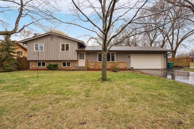 tri-level home featuring driveway, a garage, brick siding, fence, and a front lawn