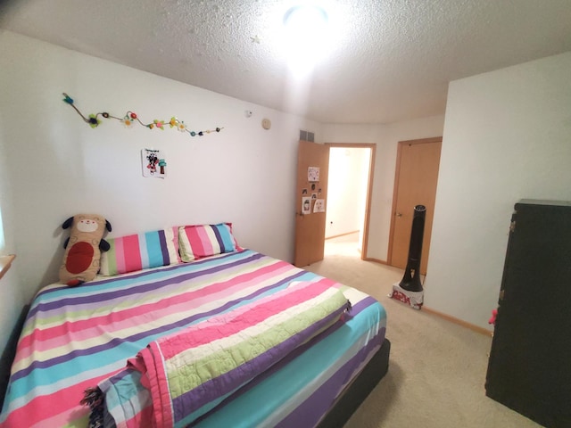 bedroom featuring a textured ceiling, visible vents, and light carpet