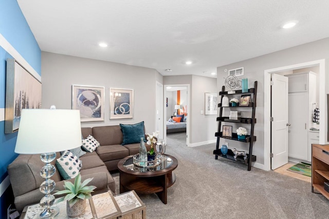 living area with baseboards, light carpet, recessed lighting, and visible vents