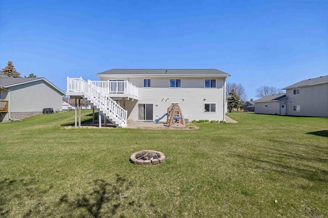 back of house with stairway, a deck, a yard, and an outdoor fire pit