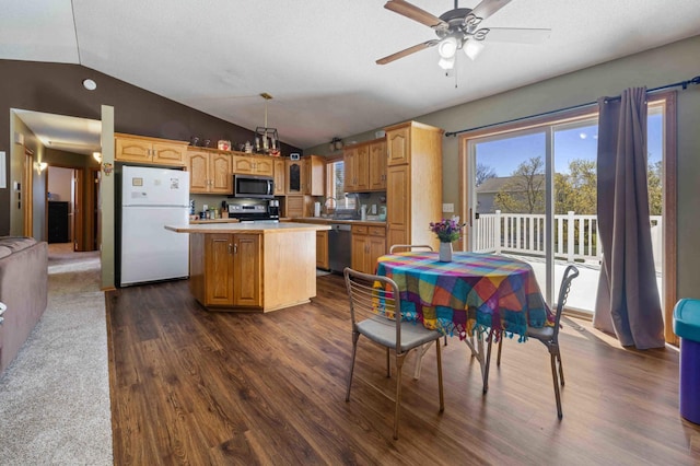 kitchen featuring appliances with stainless steel finishes, a center island, light countertops, dark wood-style floors, and lofted ceiling