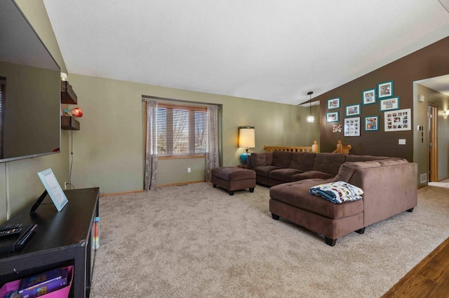 living area featuring baseboards, vaulted ceiling, and wood finished floors