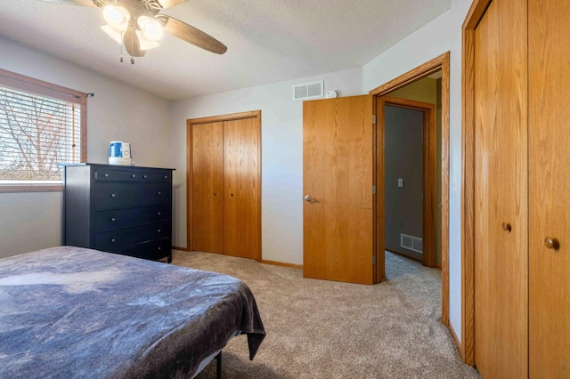 bedroom with carpet flooring, a textured ceiling, and visible vents