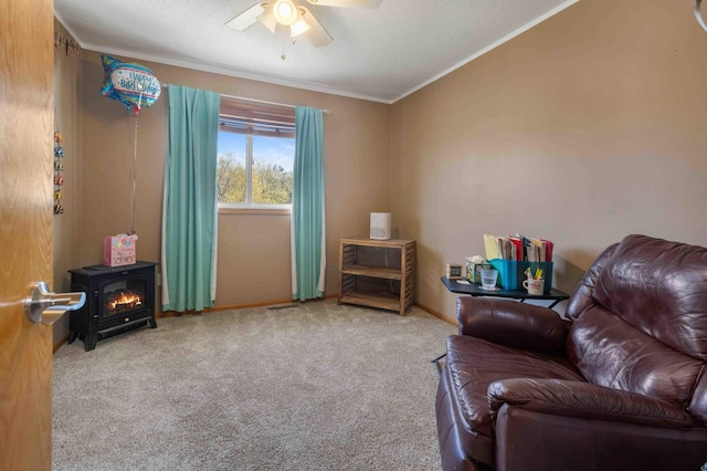 living area featuring crown molding, carpet flooring, a textured ceiling, a ceiling fan, and baseboards