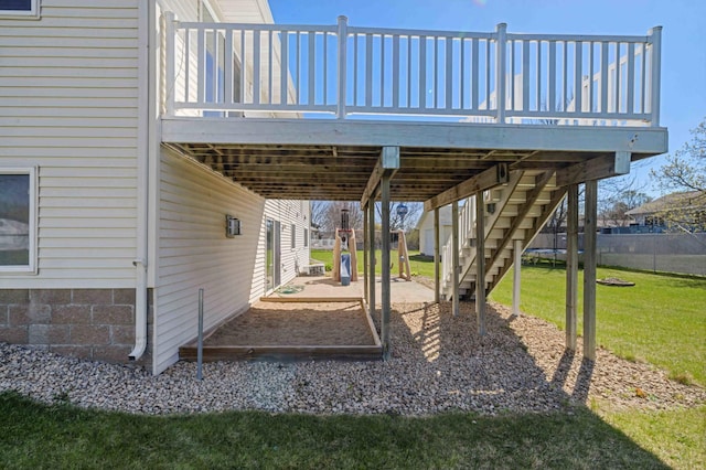 view of yard featuring a deck, fence, and stairs