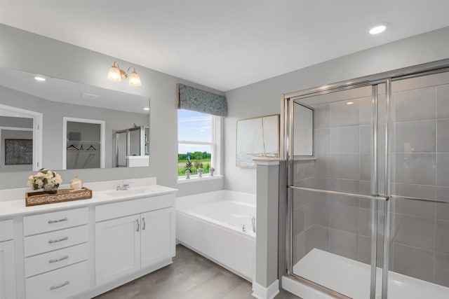 bathroom featuring a stall shower, a walk in closet, a bath, and vanity