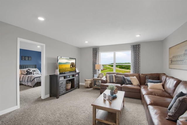 living room with recessed lighting, light colored carpet, and baseboards