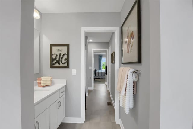hall featuring visible vents and baseboards