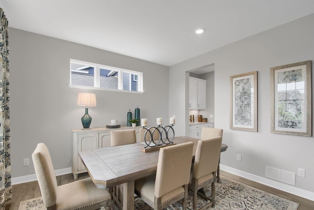 dining room featuring baseboards, visible vents, light wood finished floors, and recessed lighting