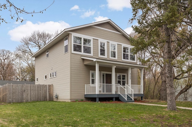 traditional-style home featuring a porch, a front yard, and fence