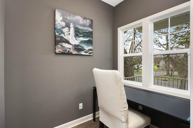 office with dark wood-style flooring and baseboards