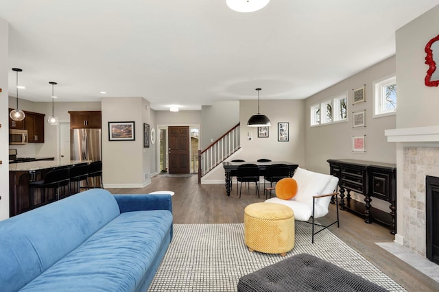 living room with recessed lighting, wood finished floors, a fireplace, baseboards, and stairway