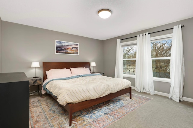 bedroom featuring light carpet and baseboards