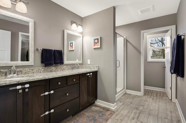 bathroom featuring baseboards, a shower stall, and a sink
