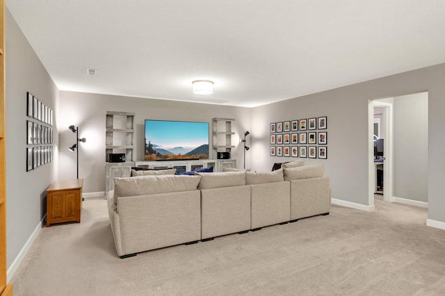 living area with baseboards and light colored carpet