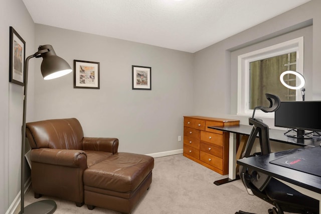 office area with baseboards, light carpet, and a textured ceiling