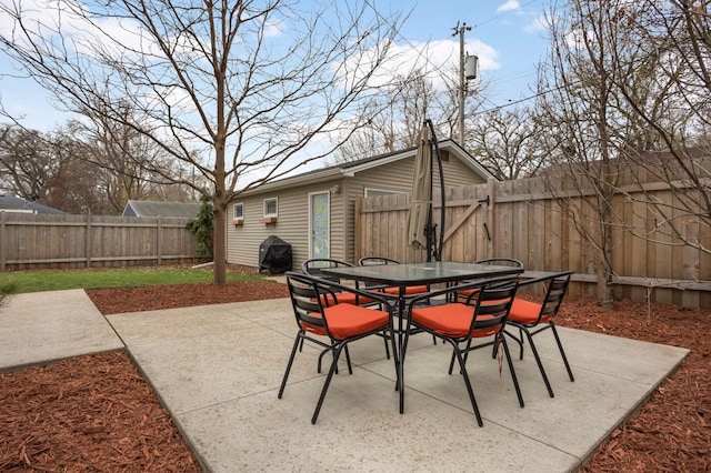 view of patio with outdoor dining area, a grill, and a fenced backyard
